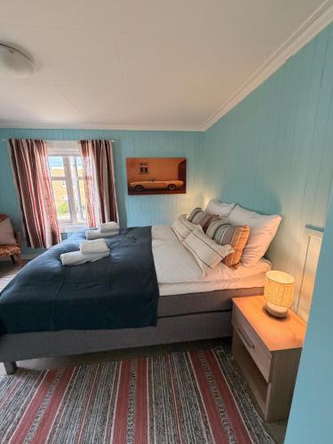 a bedroom with a large bed with blue walls at Lofoten Town Villa I Sleeps 9 in Leknes