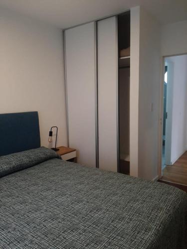 a bedroom with a bed and sliding glass doors at Spa vacacional in Mar del Plata
