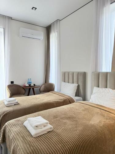 two beds in a hotel room with towels on them at Davos hotel and tours in Pʼarakʼar