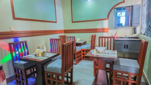 a restaurant with four tables and chairs and a sink at NIGO EXECUTIVE LODGE Mahenge in Mahenge