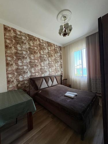 a bedroom with a bed and a brick wall at Lukas's house in Kobuleti