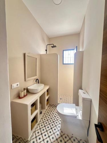 a white bathroom with a sink and a toilet at Patio del recuerdo in Benalup Casas Viejas