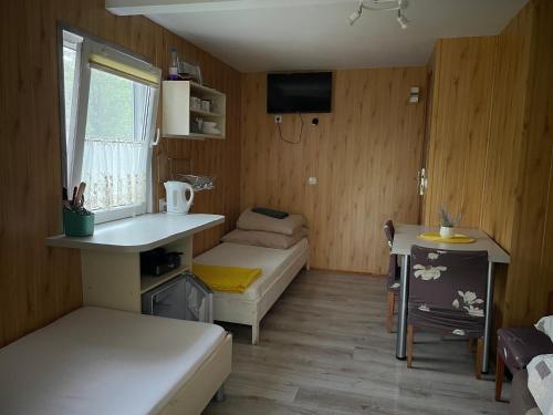 a small room with a bed and a desk at Łąkowa Dolina - domek letniskowy in Supraśl