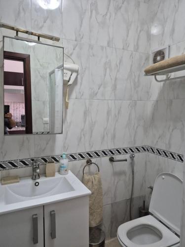 a bathroom with a sink and a toilet and a mirror at Cabo dream 75 piscine et wifi in Cabo Negro