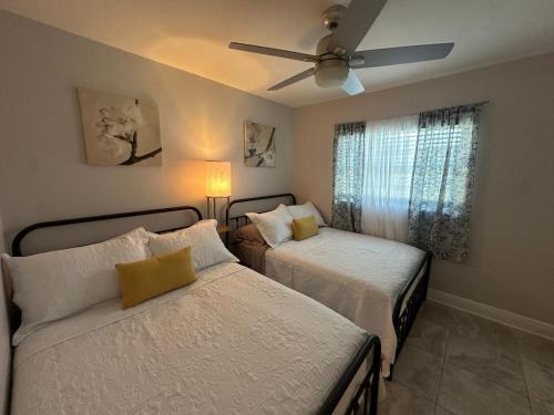 a bedroom with two beds and a ceiling fan at Escape to Tropical Tampa in Tampa