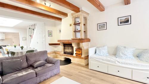 a living room with a couch and a fireplace at La Maison des Poutres & Lumières - Emile Zola in Croix