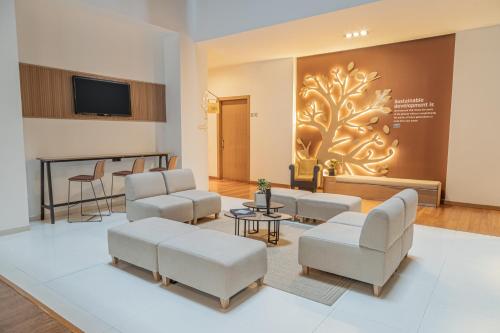a waiting room with couches and a wall with a tree mural at Biohotel Organic Suites Bogotá Usaquén in Bogotá
