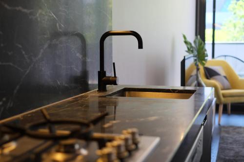 a kitchen sink with a faucet on a counter at Turnkey Accommodation-North Melbourne in Melbourne