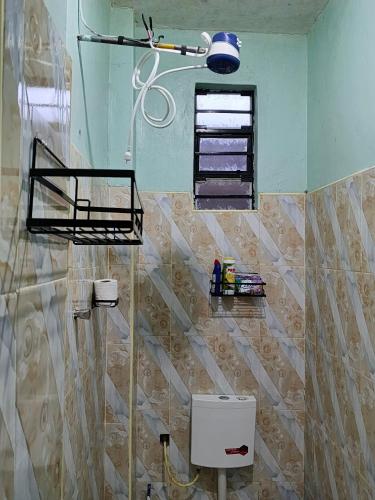 a bathroom with a toilet and a window at New Era Homes in Kimana