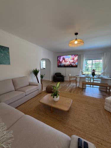 a living room with a couch and a table at Capsule Marisol Family Retreat in Corroios