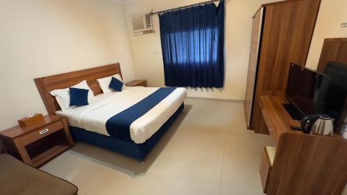 a hotel room with a bed and a television at غيوم ابها - شقق مخدومه in Abha