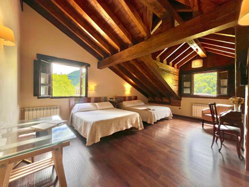 a bedroom with two beds in a room with wooden ceilings at Hotel Rural El Fundil in El Pino