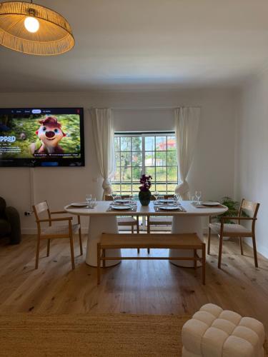 a living room with a table and a tv at Capsule Marisol Family Retreat in Corroios
