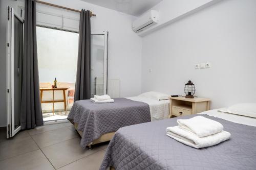 a bedroom with two beds and a window at Eudaimonia in Naxos Chora