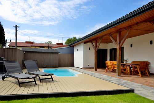 a patio with chairs and a table and a pool at BOSzKO HOUSE in Boszkowo
