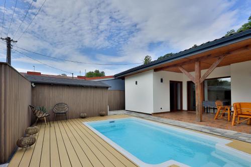 a swimming pool on a deck next to a house at BOSzKO HOUSE in Boszkowo