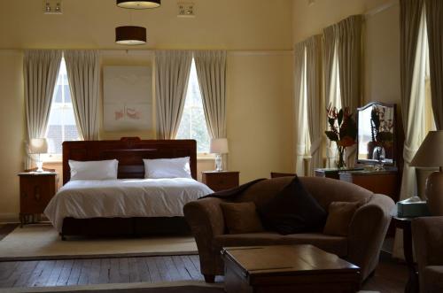 1 dormitorio con 1 cama y 1 sofá en Old Parkes Convent en Parkes