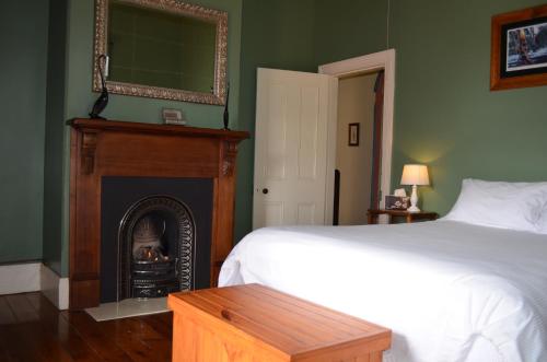 ein Schlafzimmer mit einem Bett und einem Kamin in der Unterkunft Old Parkes Convent in Parkes