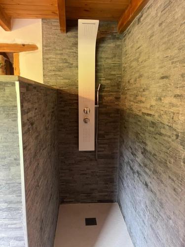 a shower in a room with a brick wall at Casa Goyo in Viego