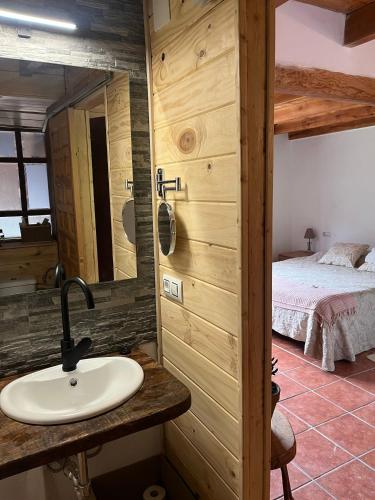 a bathroom with a sink and a bed in a room at Casa Goyo in Viego