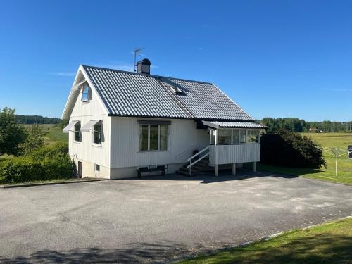 ein weißes Haus mit Dach auf einer Einfahrt in der Unterkunft Svarteborg Dingle in Dingle