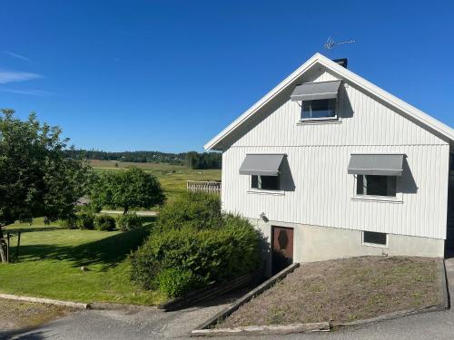 ein weißes Haus mit zwei Fenstern und einer Tür in der Unterkunft Svarteborg Dingle in Dingle