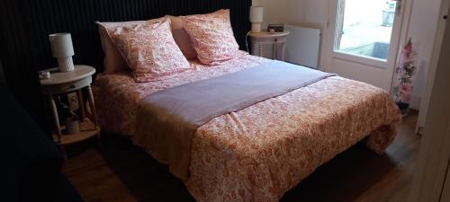 a bedroom with a bed with pink sheets and pillows at Cas'ArtiGè in Troyes