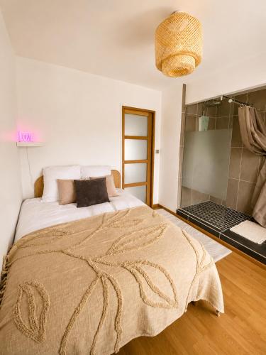 a bedroom with a large bed with a blanket on it at La parenthèse in Calais