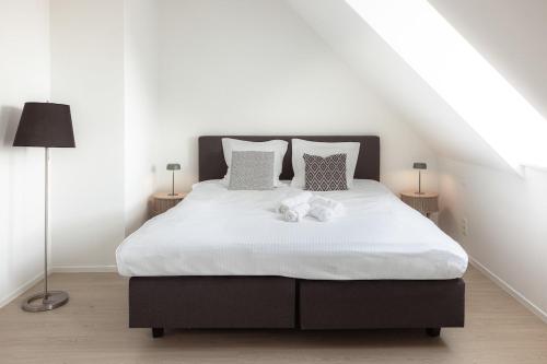 a bedroom with a bed with two stuffed animals on it at Sunny duplex penthouse, close to beach, parking in Knokke-Heist