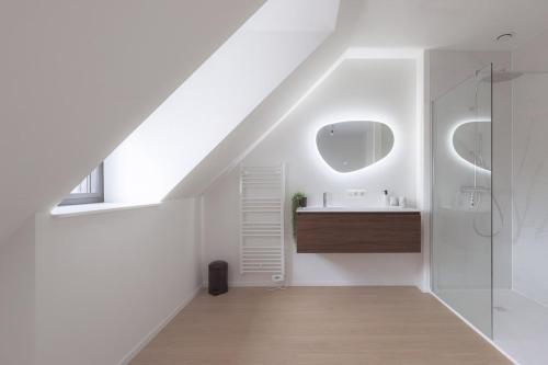a white bathroom with a sink and a shower at Sunny duplex penthouse, close to beach, parking in Knokke-Heist