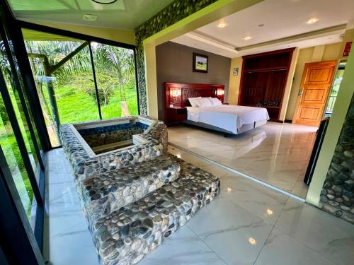 a bedroom with a bed and a couch in a room at Hosteria Arizona in Puyo