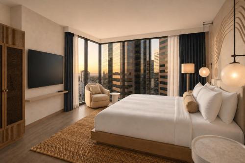 a bedroom with a large white bed and a large window at Denu Hotel & Spa in Phoenix