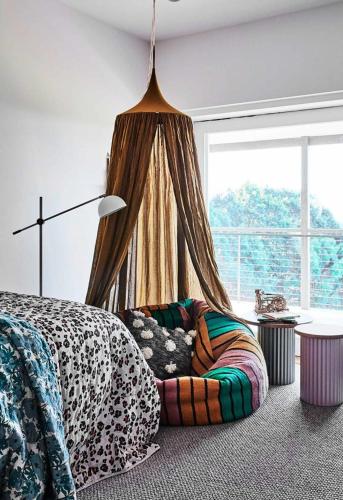 a bedroom with a bed with a leopard blanket and a window at Byron Retreat in Coopers Shoot