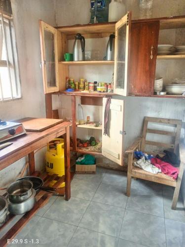 a kitchen with wooden cabinets and a table in it at WYCLIFF BnB in Chabahinga