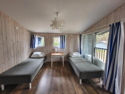 a room with two beds and a table in it at Archipelag in Ustka