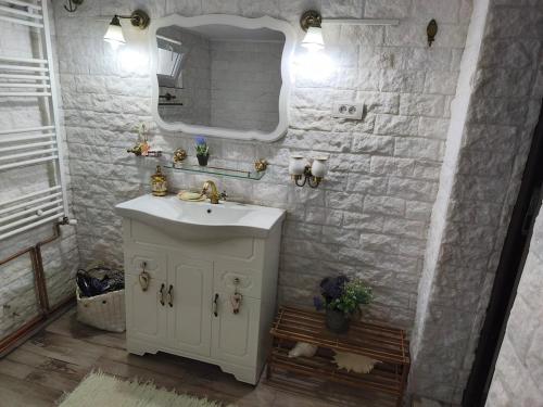 a white bathroom with a sink and a mirror at Casa Luna in Călimăneşti