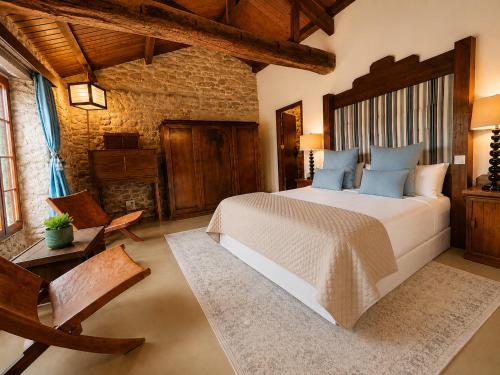 a bedroom with a large bed and a brick wall at Elemergia in Irijoa
