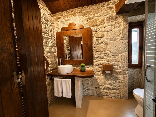 a stone bathroom with a sink and a mirror at Elemergia in Irijoa