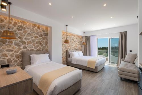 a hotel room with two beds and a couch at Pantheon Hotel in Kefalos