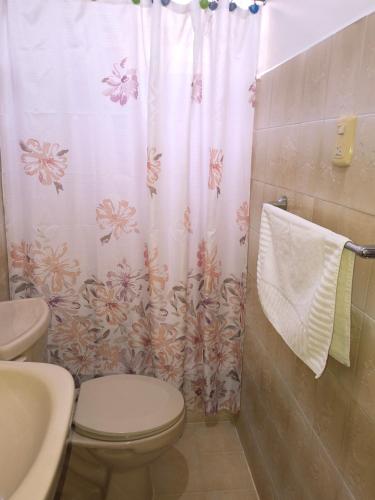 a bathroom with a toilet and a shower curtain at Hotel La Morada in Santo Domingo