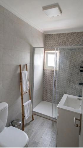 a bathroom with a shower and a toilet and a sink at Refúgio Viçoso in Vila Viçosa