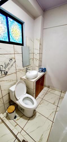 a bathroom with a toilet and a sink and a window at Romantic Suite with Pool in Fortuna
