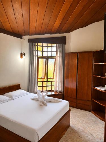 a bedroom with a large bed with a window at Hotel Fazenda Morada Do Verde in Campo Limpo