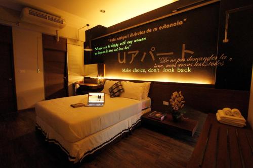 a hotel room with a bed with a sign on the wall at U431 Chaengwattana in Nonthaburi