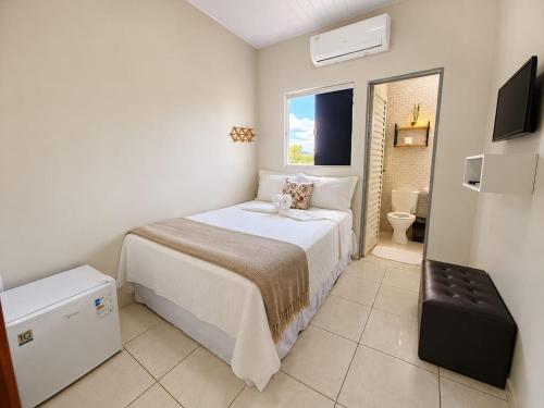 a small bedroom with a bed and a toilet at Pousada Aurora Nascer do sol 1 in Manhã