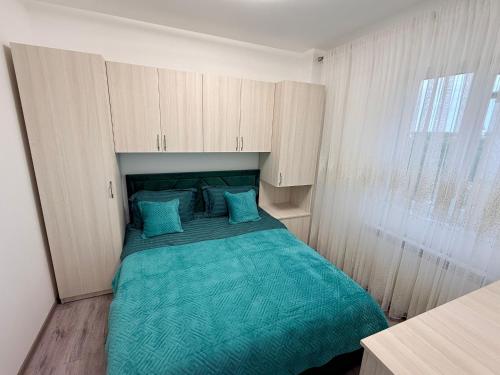 a bedroom with a bed with a green comforter at Miry Apartment in Târgu Neamț