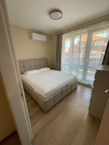 a bedroom with a bed and a large window at Medoni Summer Hive in Sozopol