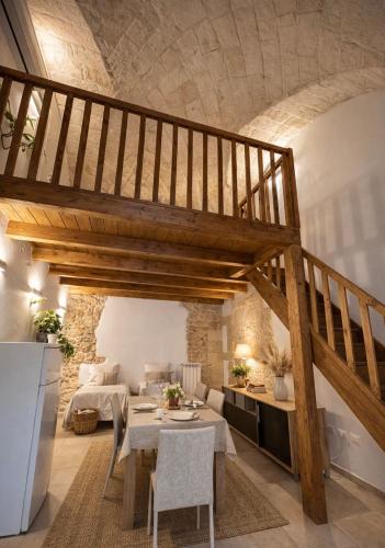 a living room with a staircase and a table and chairs at Piazza San Giorgio B&B in Serrano