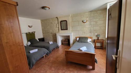 a bedroom with two beds and a table in it at Centre Bourg d'Avoine Cottage in Avoine