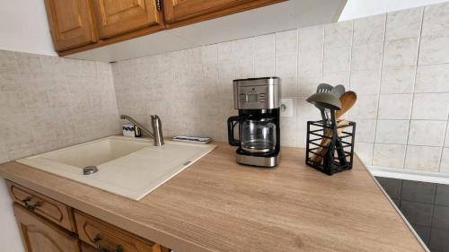 a kitchen counter with a coffeemaker and a coffee maker at Centre Bourg d'Avoine Cottage in Avoine